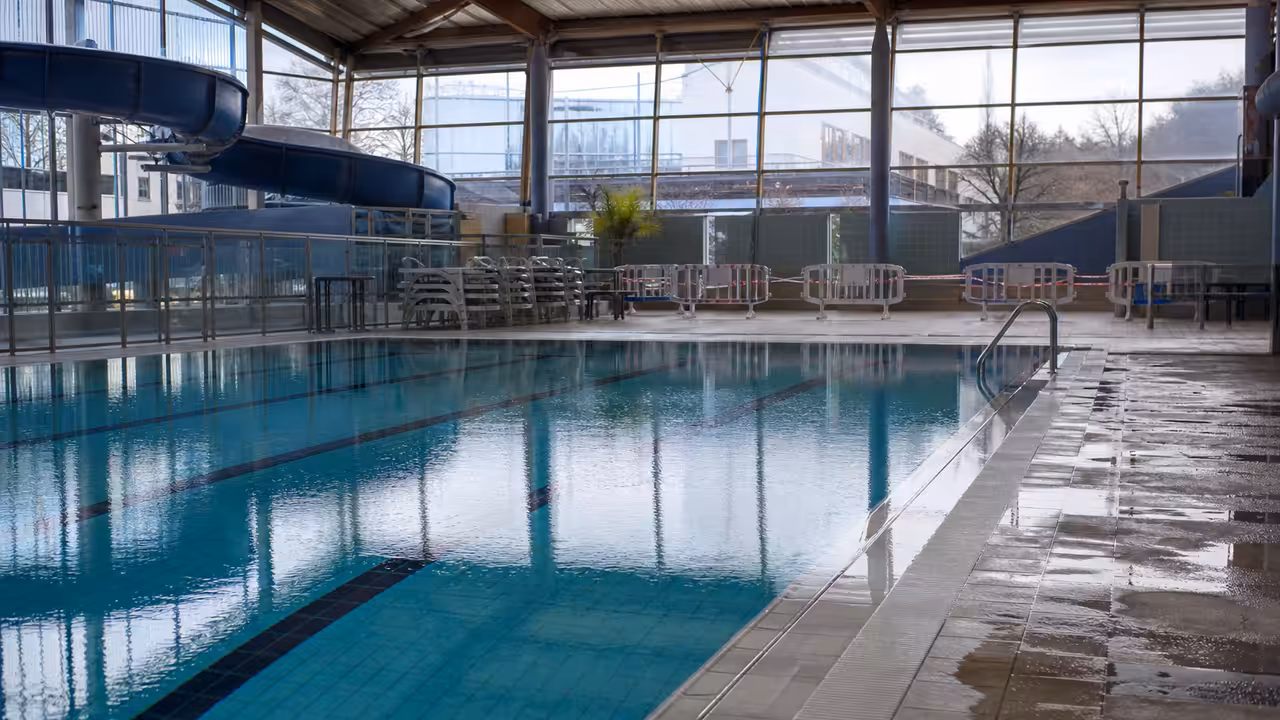 Plages humides et bassin intérieur vide dans un centre aquatique préparé pour une fermeture temporaire