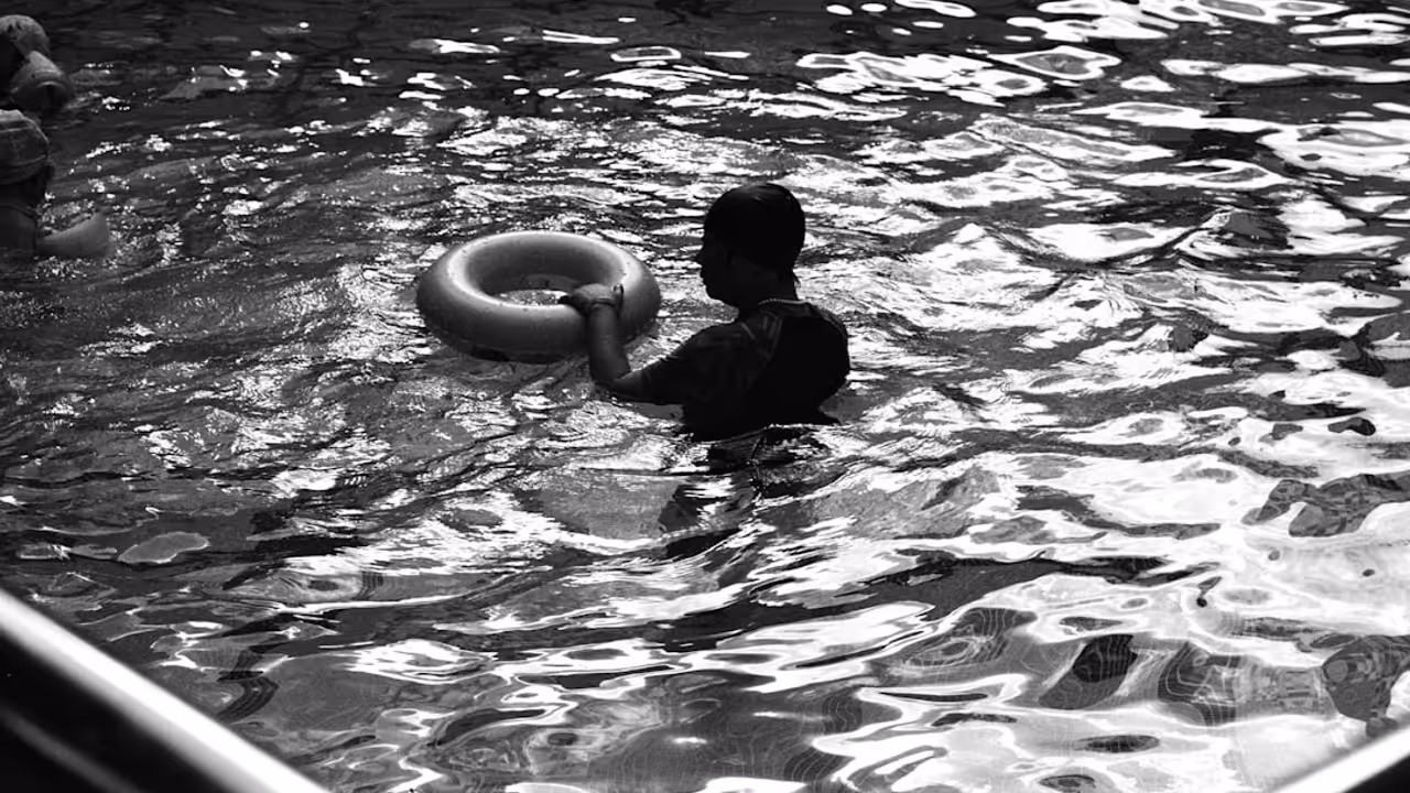 Entrée d’une piscine municipale française avec des usagers attendant devant les portes vitrées du bâtiment