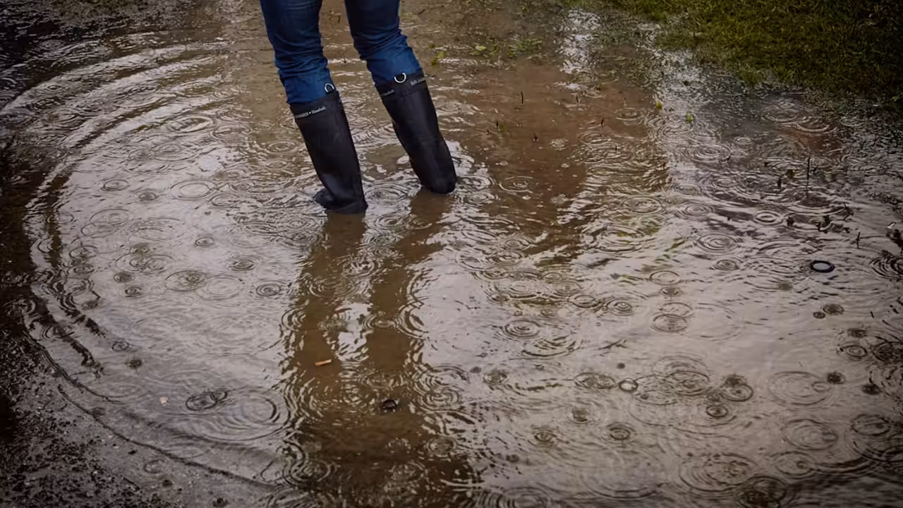 Parking souterrain d'une résidence envahi par l'eau de pluie, avec véhicules immobilisés au fond