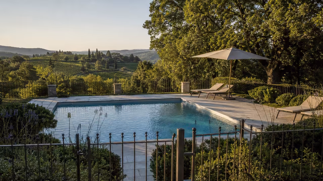 Piscine privée sécurisée dans un jardin, avec barrière fermée, transats et végétation en arrière-plan