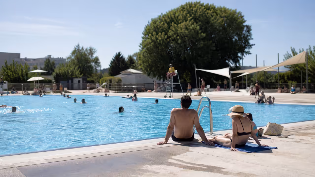 Bassin municipal fréquenté par des adultes se rafraîchissant lors d’une chaude journée d’été