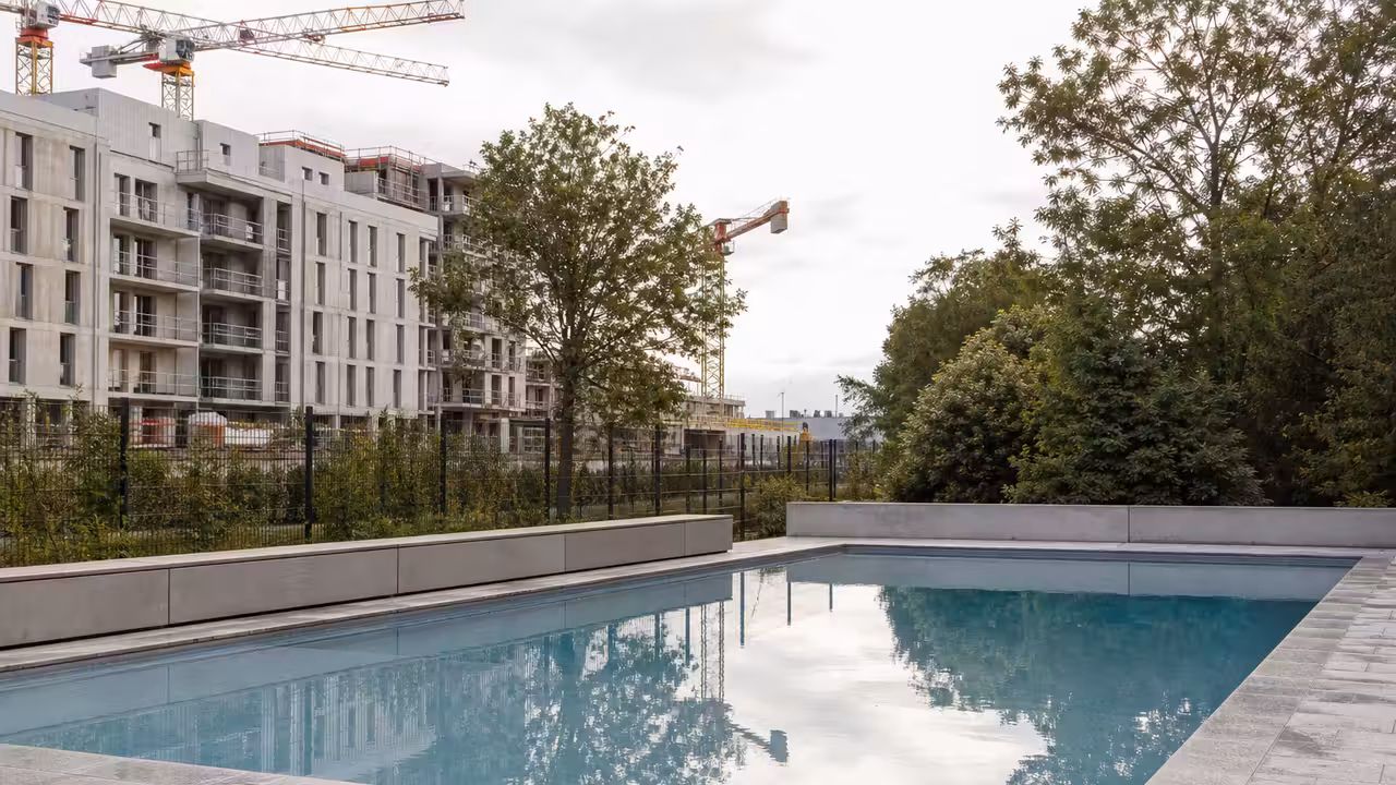 Piscine privée urbaine bordée d’un bâtiment contemporain, illustrant les enjeux d’ombre et de voisinage