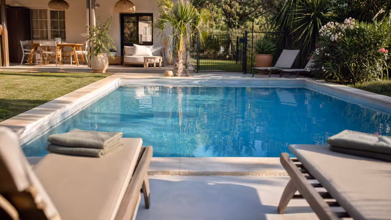Piscine privée sécurisée dans un jardin toulousain, avec terrasse, parasol et barrière de protection