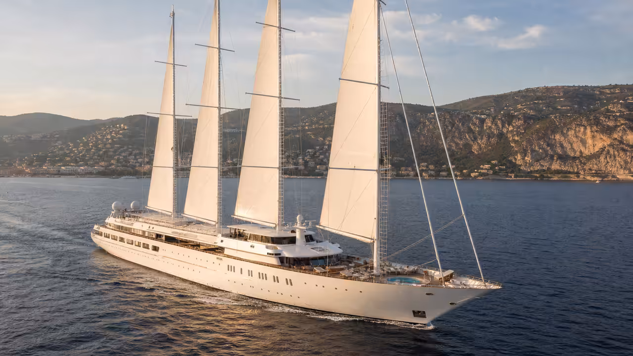 Grand voilier de luxe à trois mâts naviguant au large de la Côte d’Azur par lumière de fin de journée