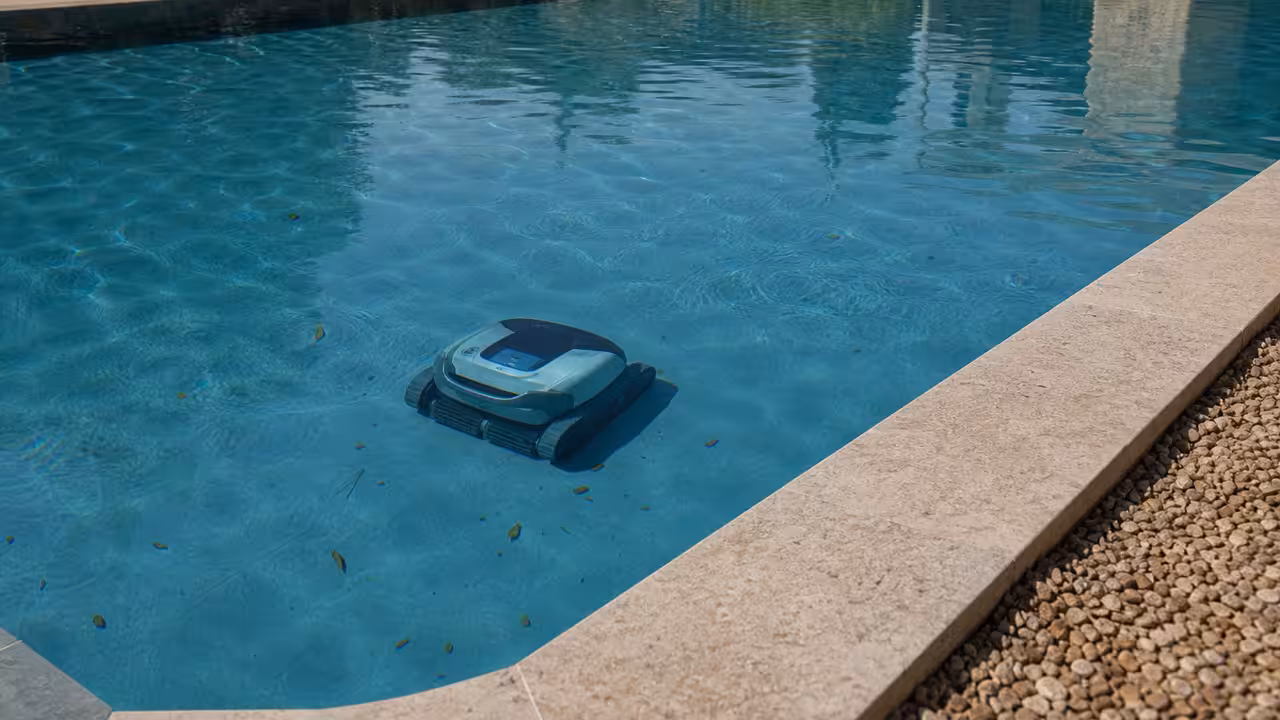 Robot de piscine sans fil en cours de nettoyage au fond d’un bassin résidentiel aux parois claires