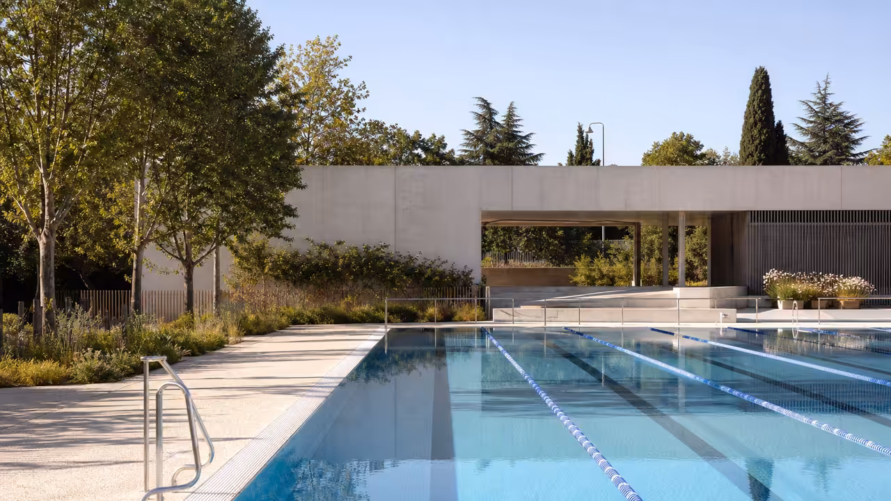 Bassin extérieur de 50 mètres d'une piscine municipale rénovée, avec lignes d'eau et bâtiment contemporain