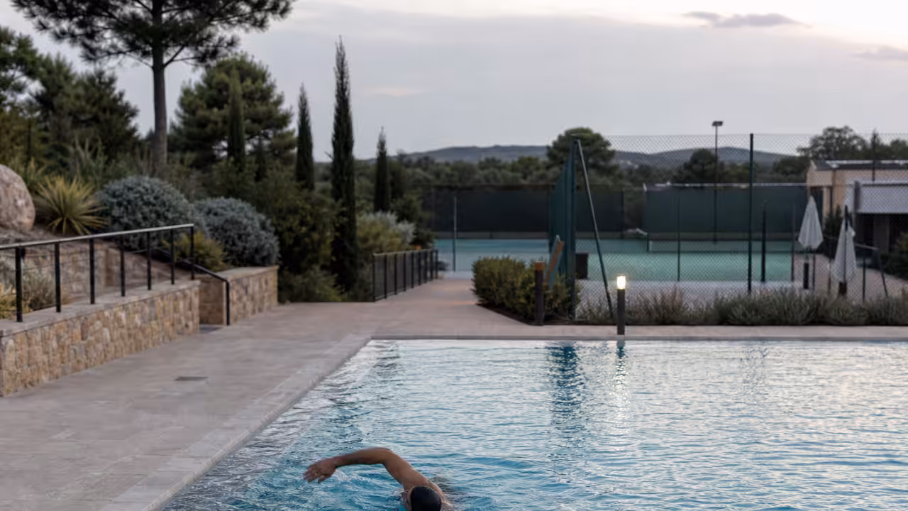 Nageur adulte effectuant quelques longueurs lentes dans une piscine extérieure chauffée après un effort sportif