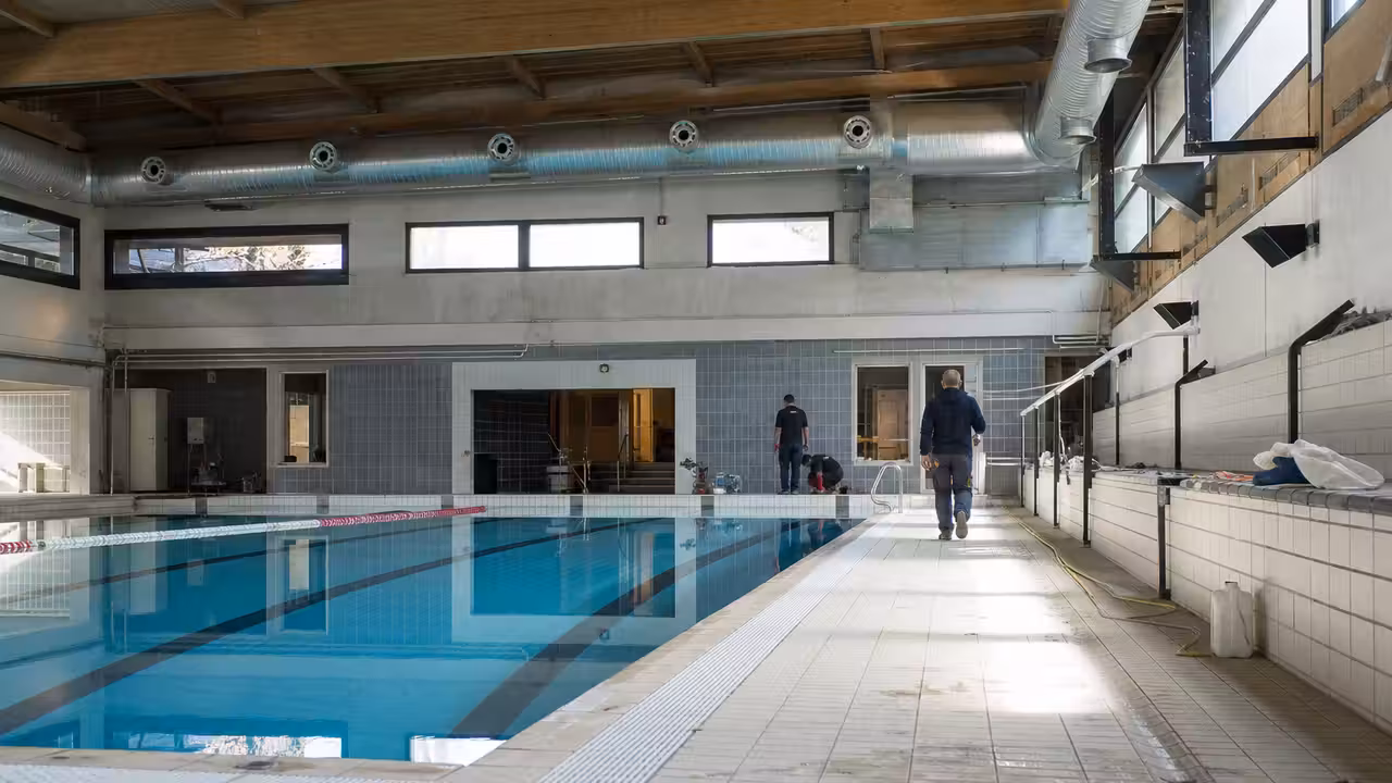 Bassin municipal couvert avec lignes d’eau, vestiaires rénovés et équipements techniques en arrière-plan