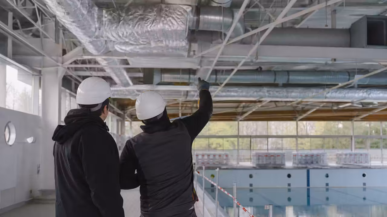 Bassin de piscine publique vide pendant une intervention technique sur les gaines de ventilation