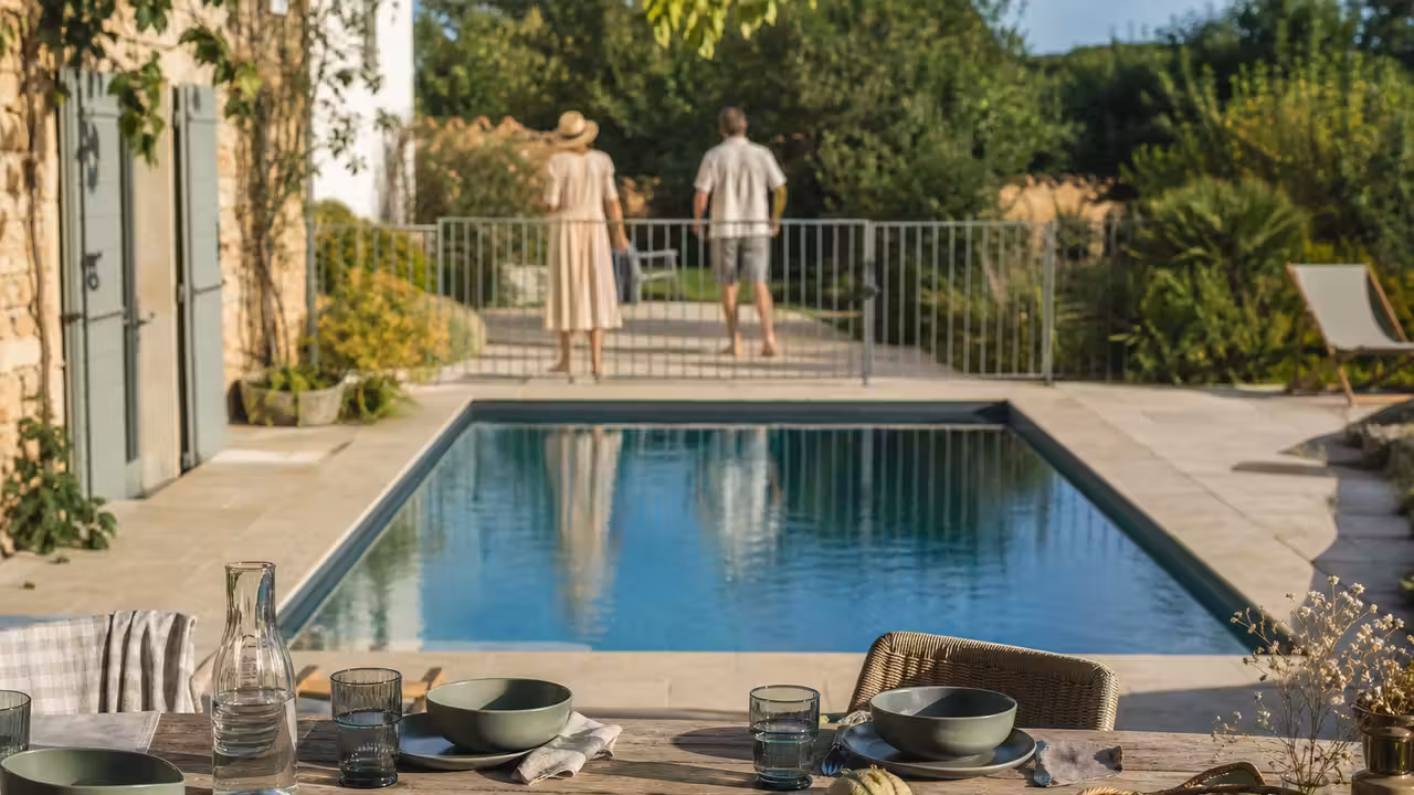 Table de brunch en vaisselle incassable installée en retrait d’une piscine familiale sécurisée