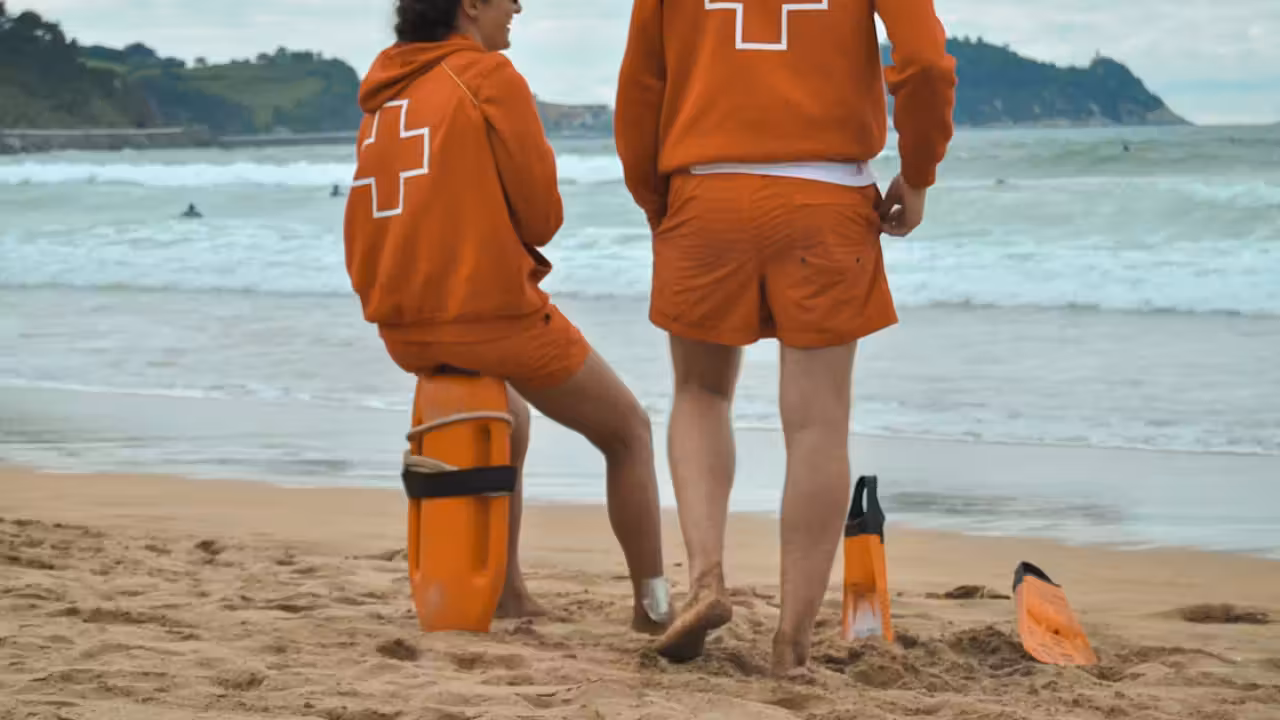 Un bassin municipal extérieur surveillé depuis une chaise haute, avec lignes d’eau et plage presque vide