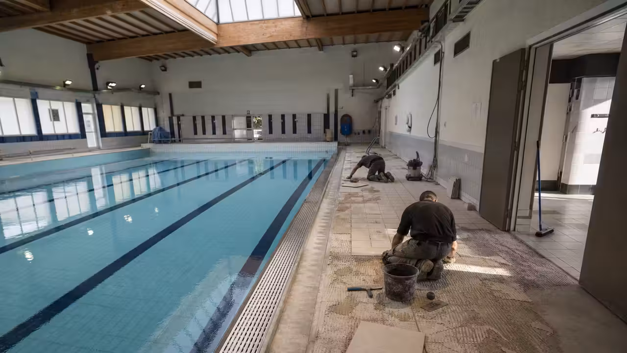 Bassin sportif vide d’une piscine municipale pendant des travaux de rénovation des plages et vestiaires