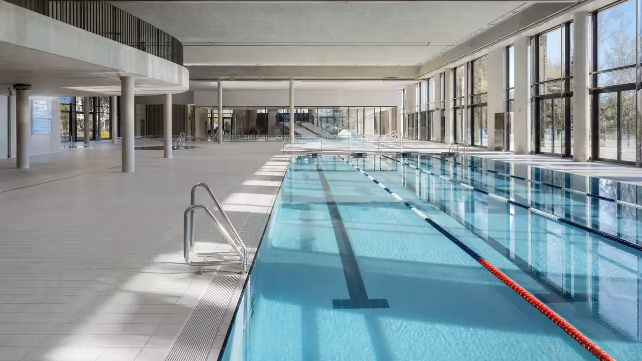 Bassin municipal de 25 mètres à six couloirs, baies vitrées et cheminement de plain-pied