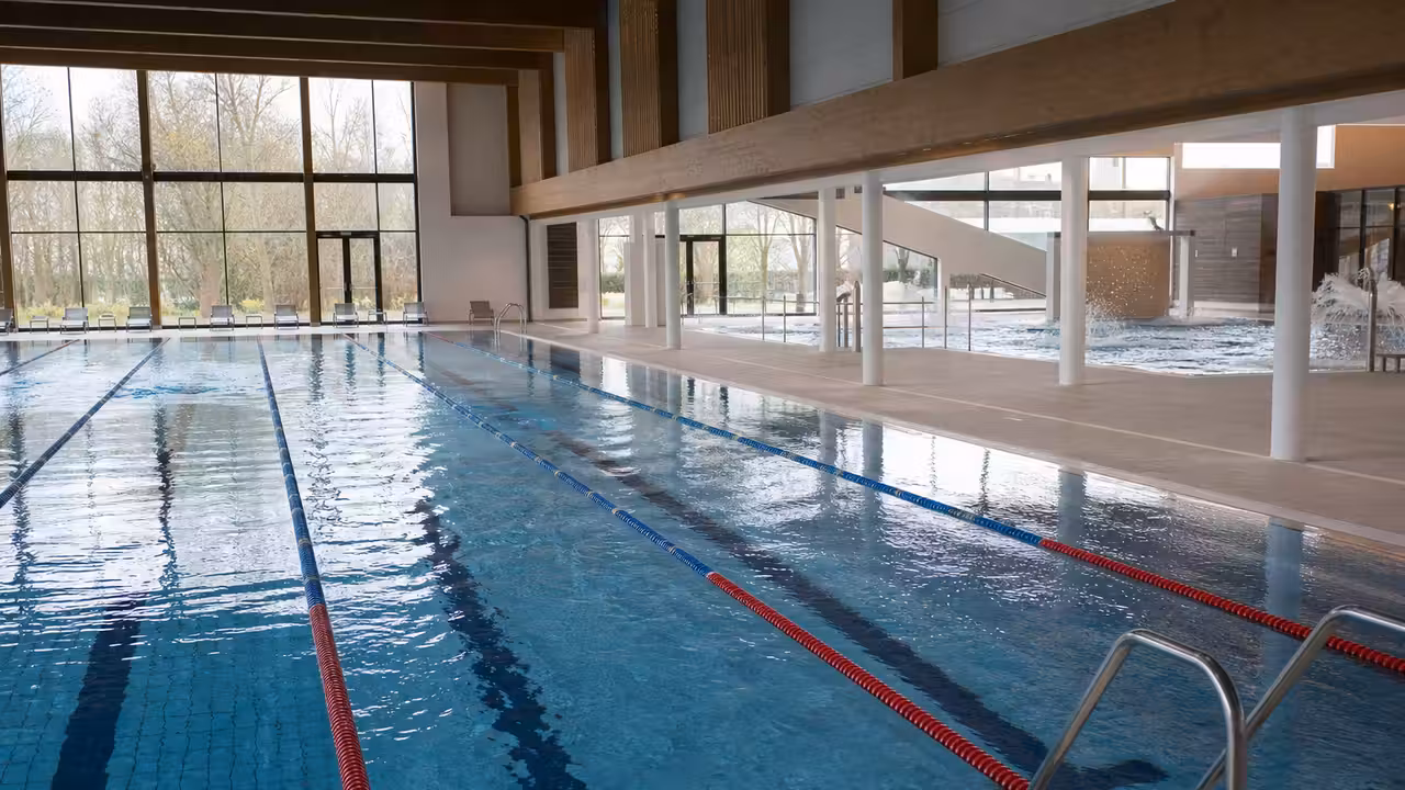 Bassin sportif intérieur de 25 mètres avec six lignes d’eau dans un centre aquatique lumineux