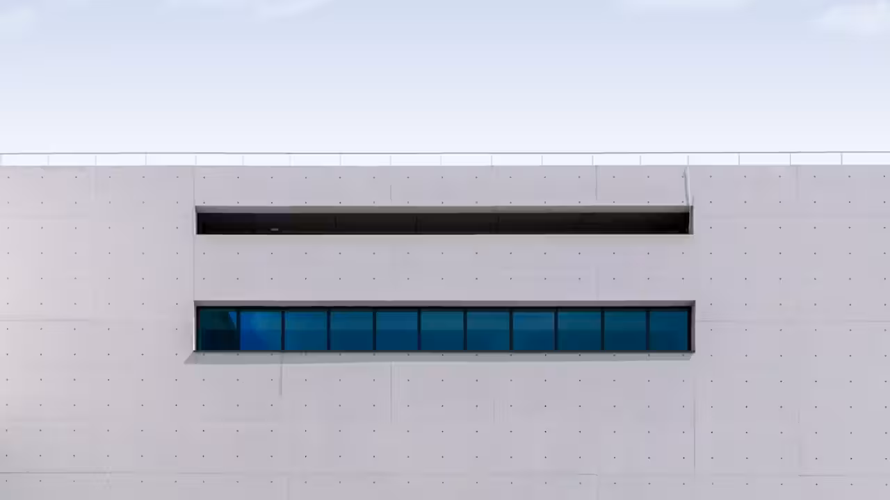 Piscine conteneur en acier installée sur une terrasse bois dans un jardin côtier lumineux