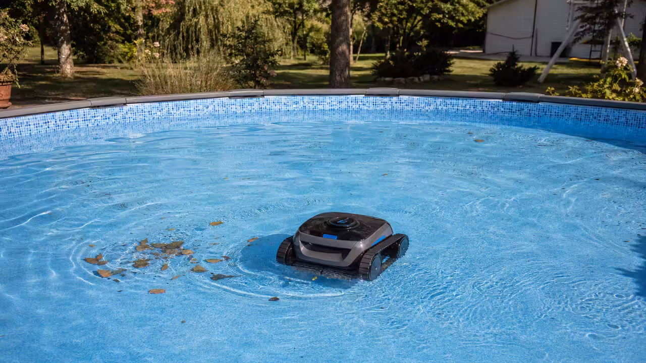 Robot électrique autonome nettoyant le fond d’une piscine hors sol à liner, avec eau claire et panier visible