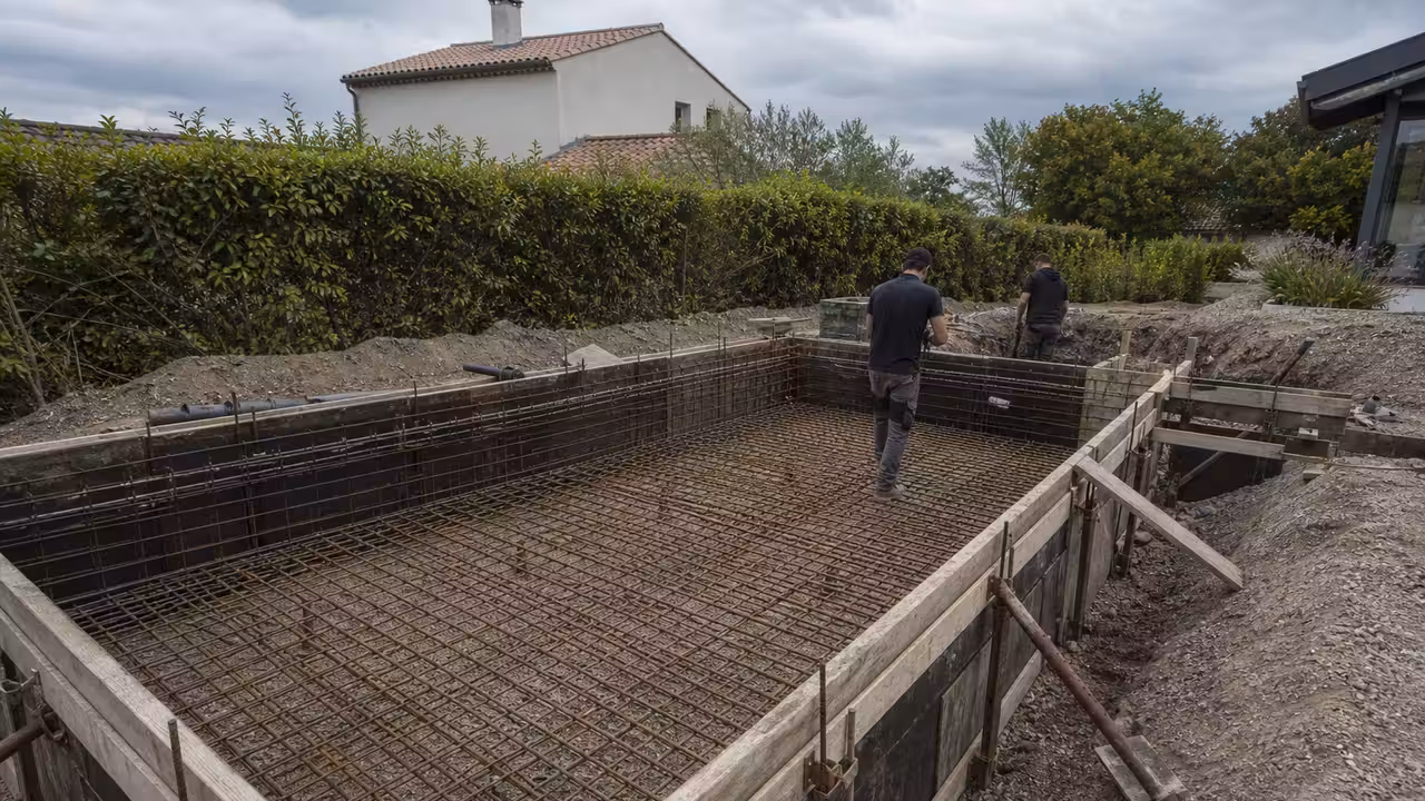 Chantier d’une piscine en béton armé avec ferraillage du radier et coffrage des parois avant coulage