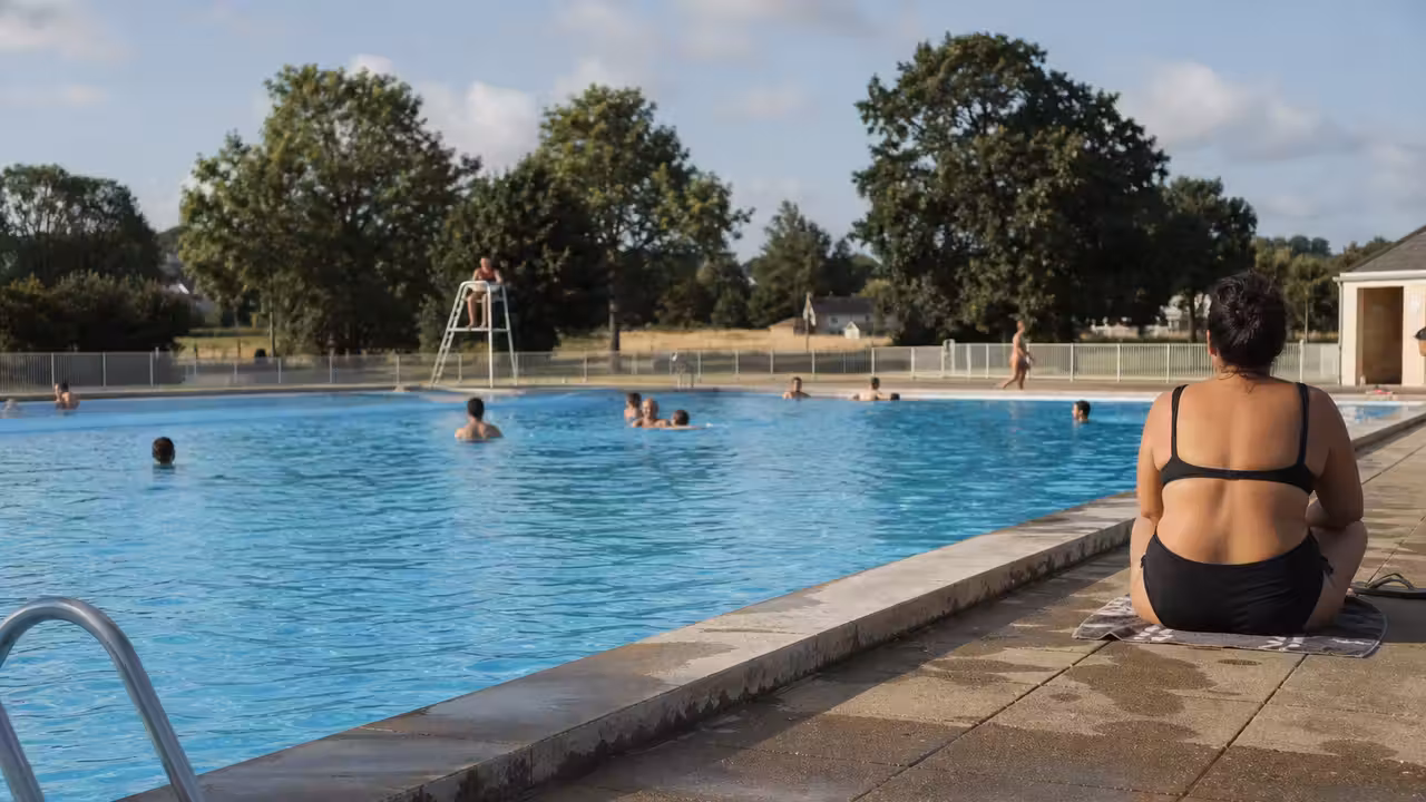 Bassin extérieur d’une piscine de proximité bretonne fréquenté par des nageurs lors d’une journée d’été