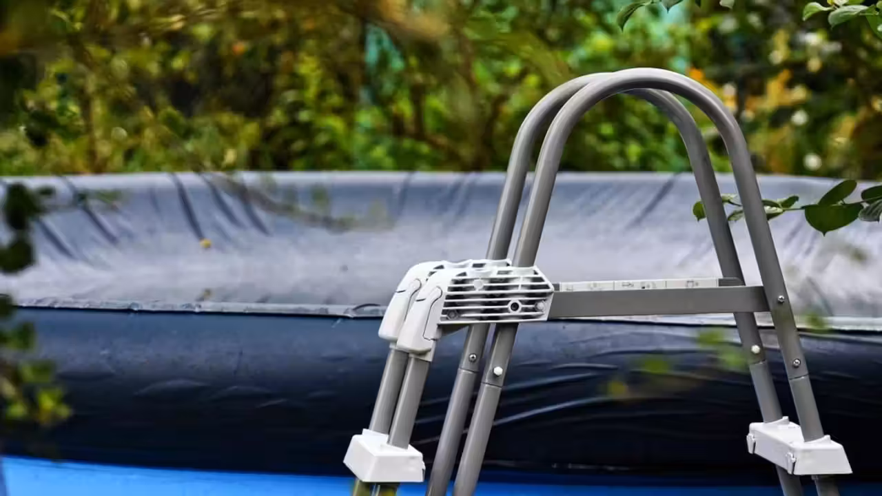 Volet roulant blanc fermé sur une piscine rectangulaire entourée de margelles en pierre claire