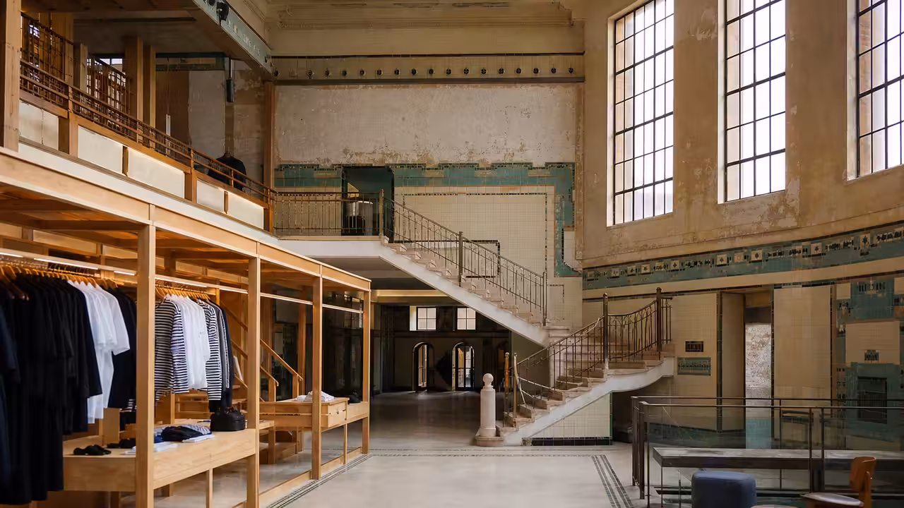 Ancienne halle de piscine Art Déco aux murs émaillés, reconvertie en espace commercial lumineux à Paris