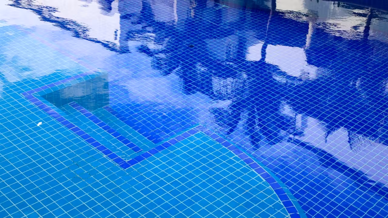 Piscine privée sécurisée dans un jardin, préparée pour accueillir un groupe de locataires en été