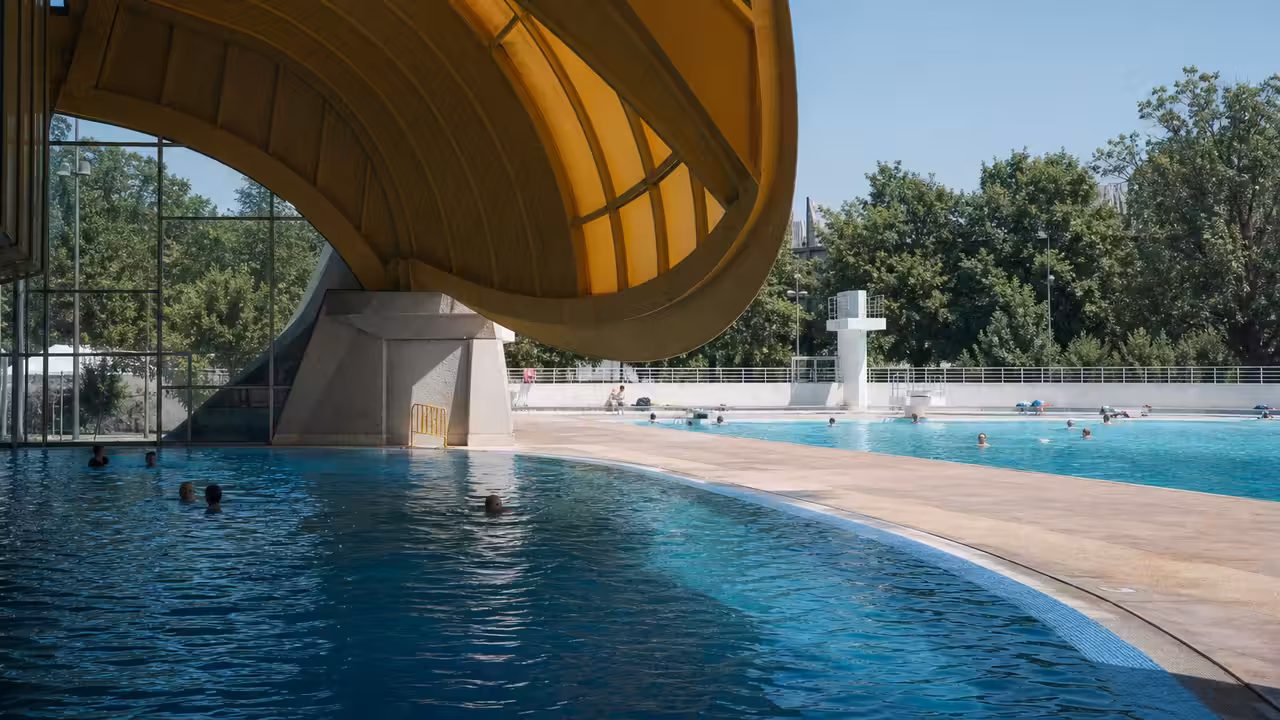 Vue extérieure de la piscine Tournesol des Lilas, avec sa coupole ouverte et ses plages de bassin en été