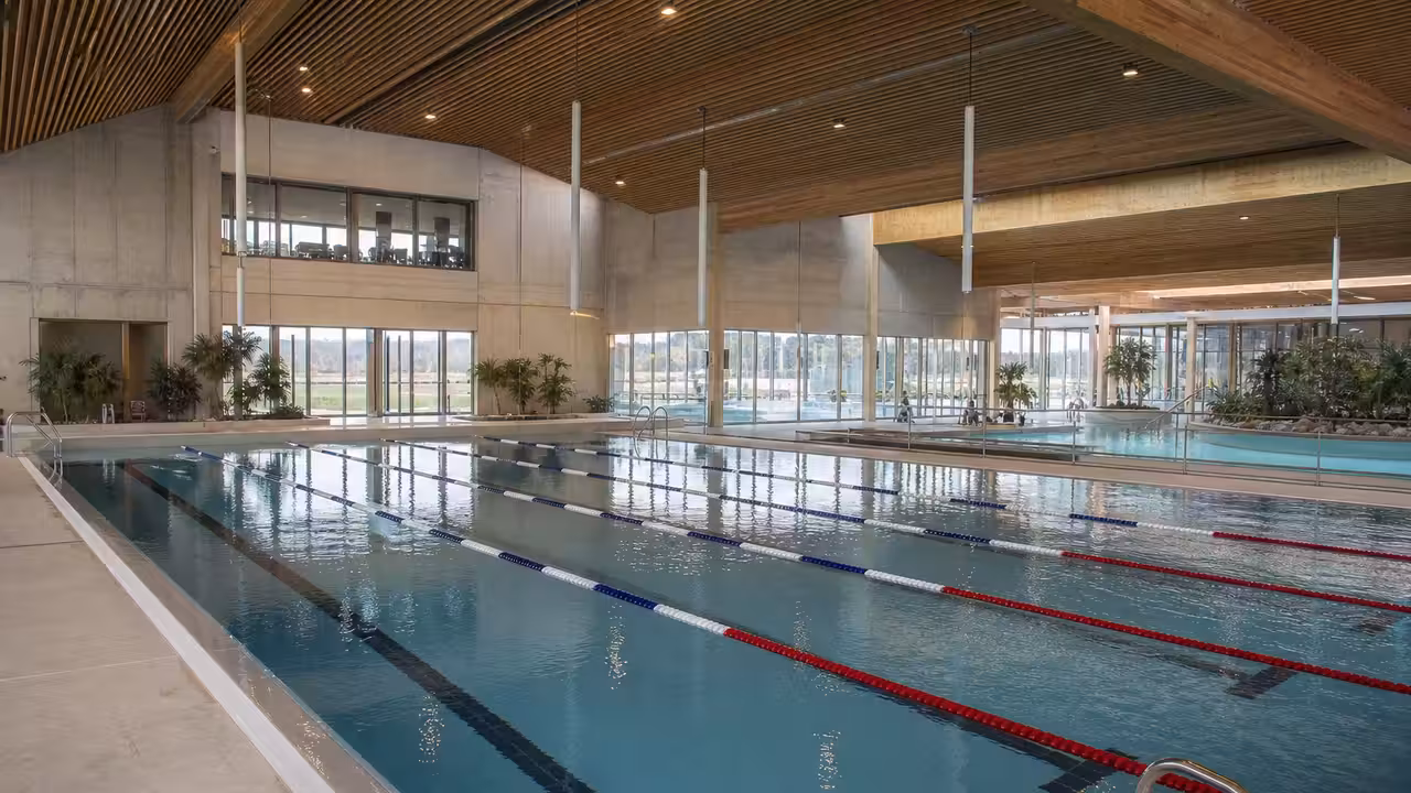 Vue intérieure lumineuse d’un bassin sportif de 25 mètres dans un centre aquatique public moderne