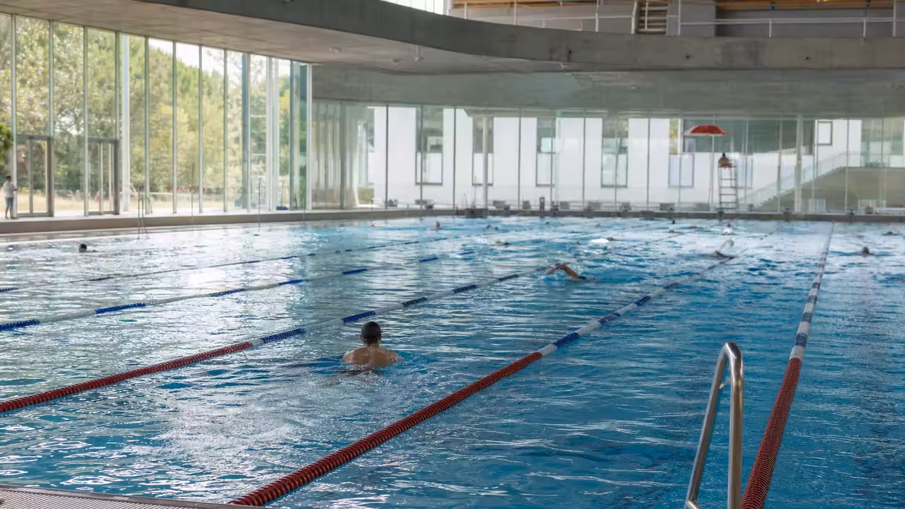Bassin de natation couvert de 50 mètres avec lignes d’eau dans un centre aquatique urbain à Genève