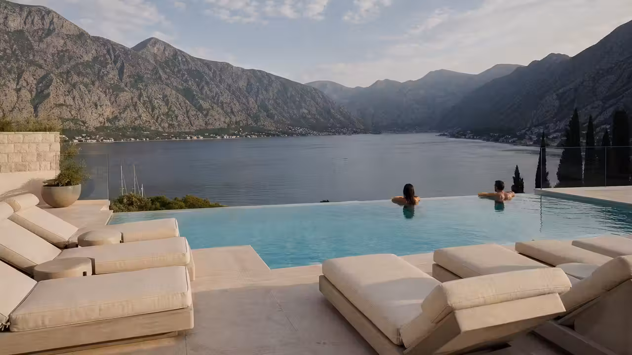 Piscine à débordement sur un rooftop face à la baie de Kotor et aux montagnes du Monténégro
