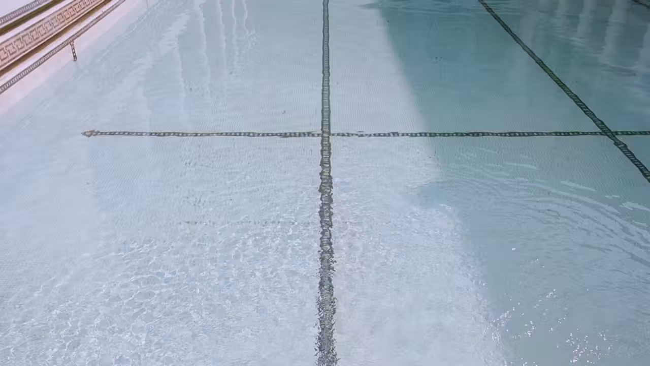Bassin extérieur de 50 mètres bordé de lignes d’eau dans un complexe sportif toulousain