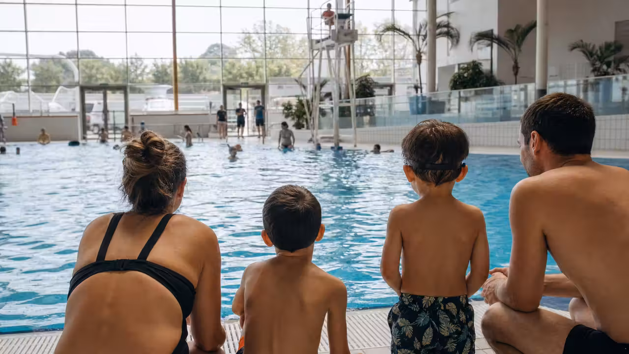 Enfants et accompagnants au bord d’un bassin public avant une séance de découverte aquatique