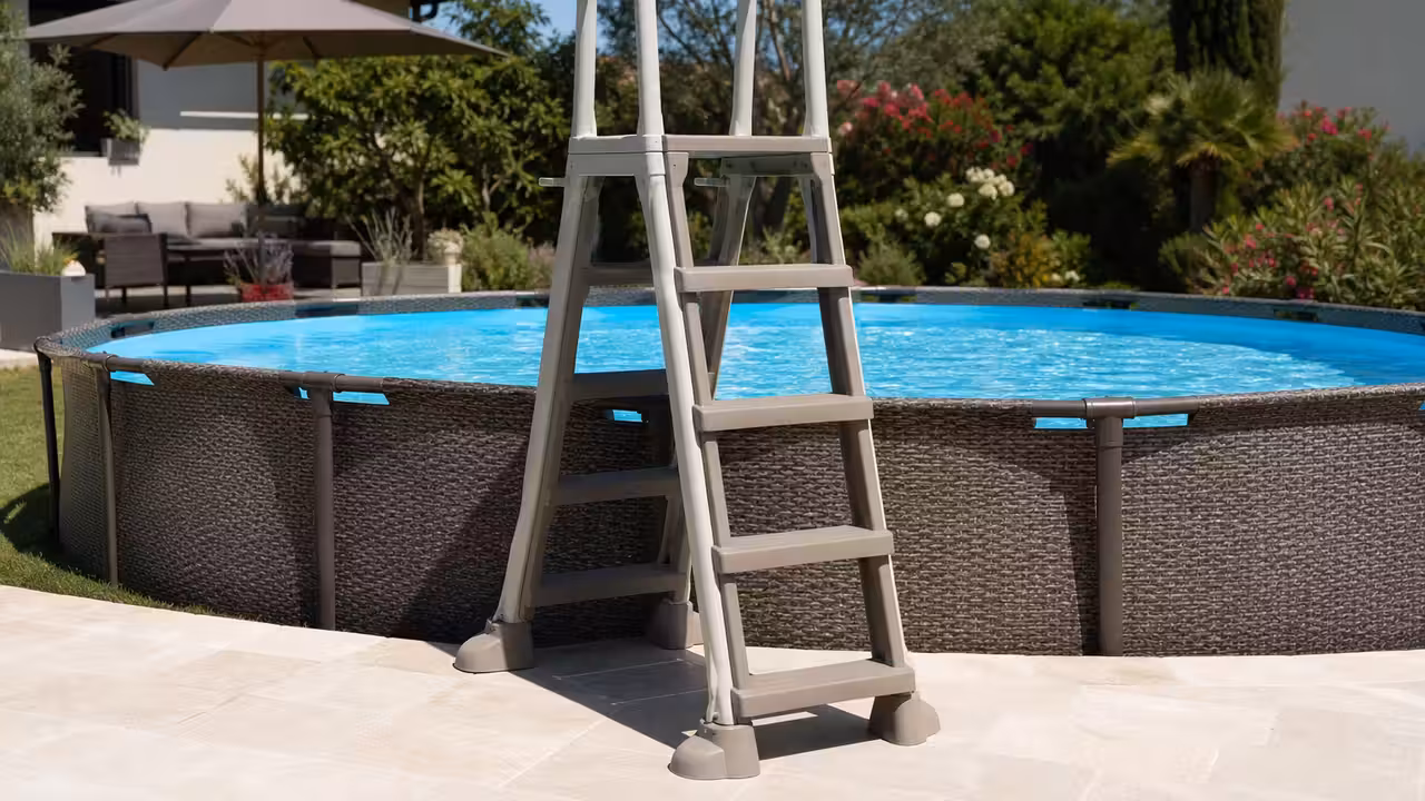 Échelle en A à marches antidérapantes installée contre une piscine hors-sol dans un jardin sécurisé