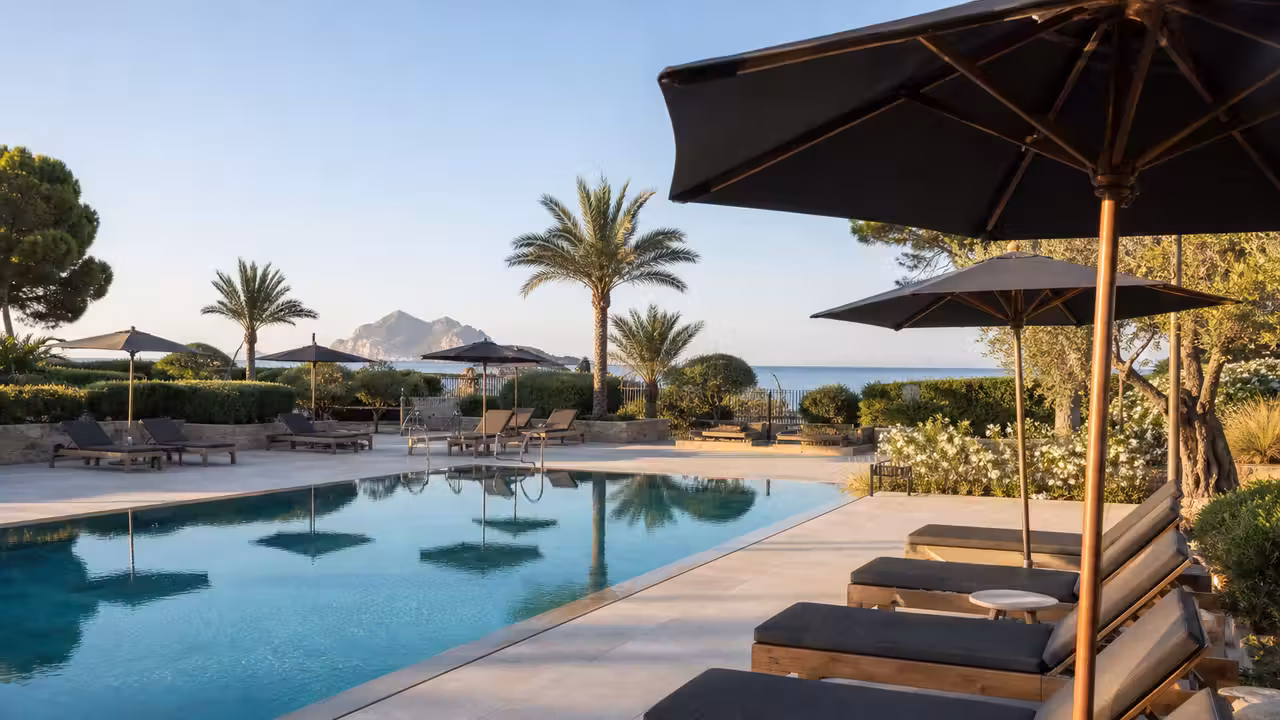 Transats alignés et zones ombragées autour d’une piscine d’hôtel, avant l’arrivée des vacanciers