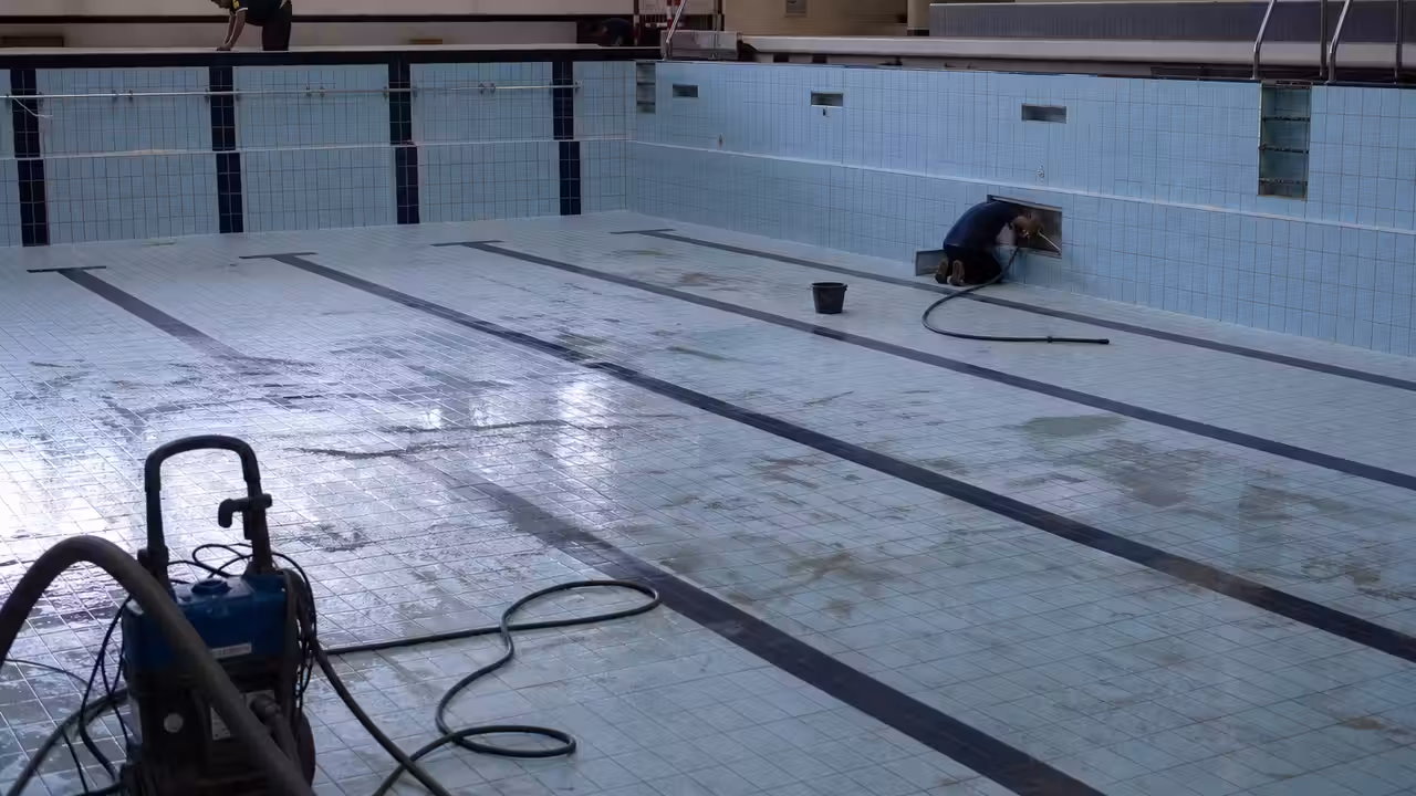 Bassin public vidé pendant une opération de nettoyage et de contrôle des équipements de piscine