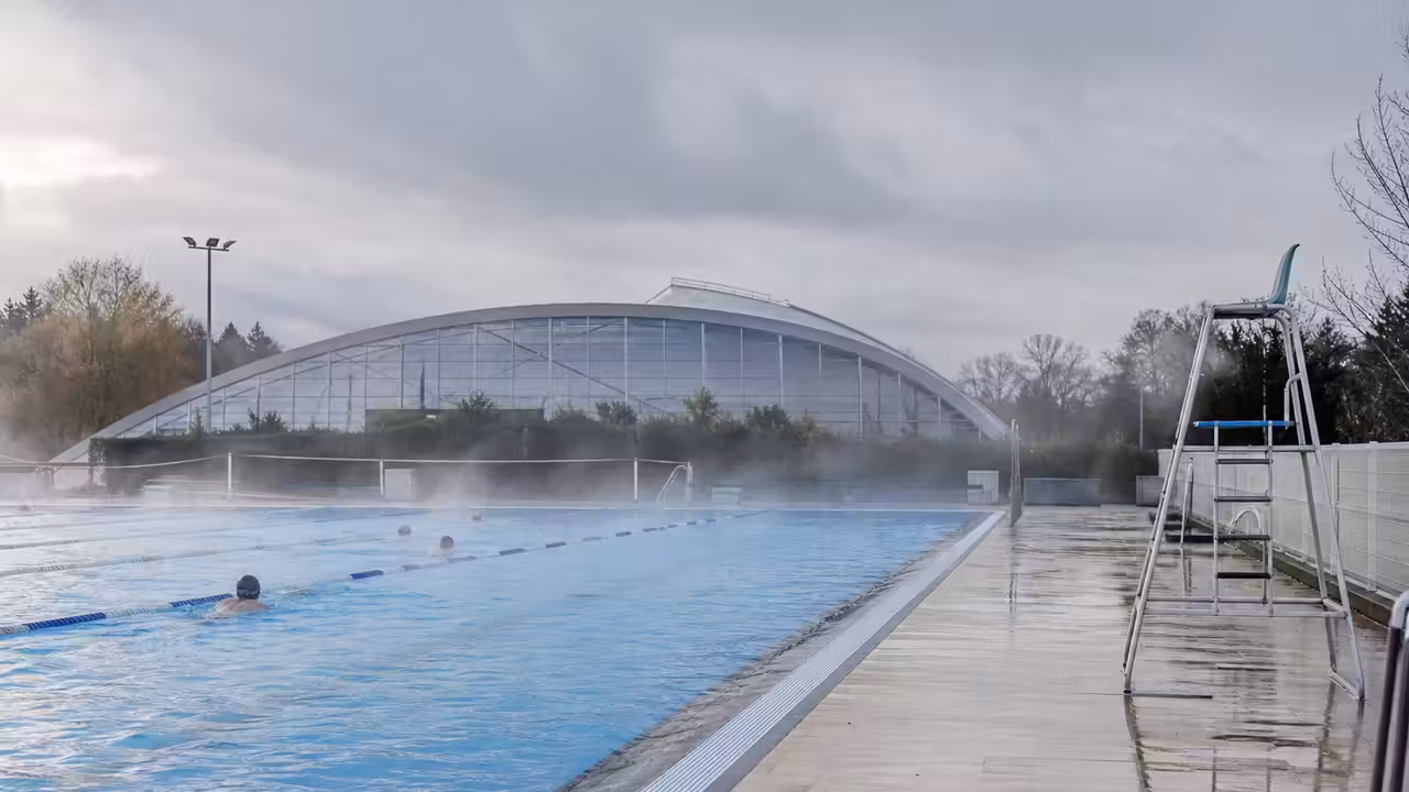 Bassin extérieur de 25 mètres fumant légèrement par temps froid dans un centre aquatique des Yvelines