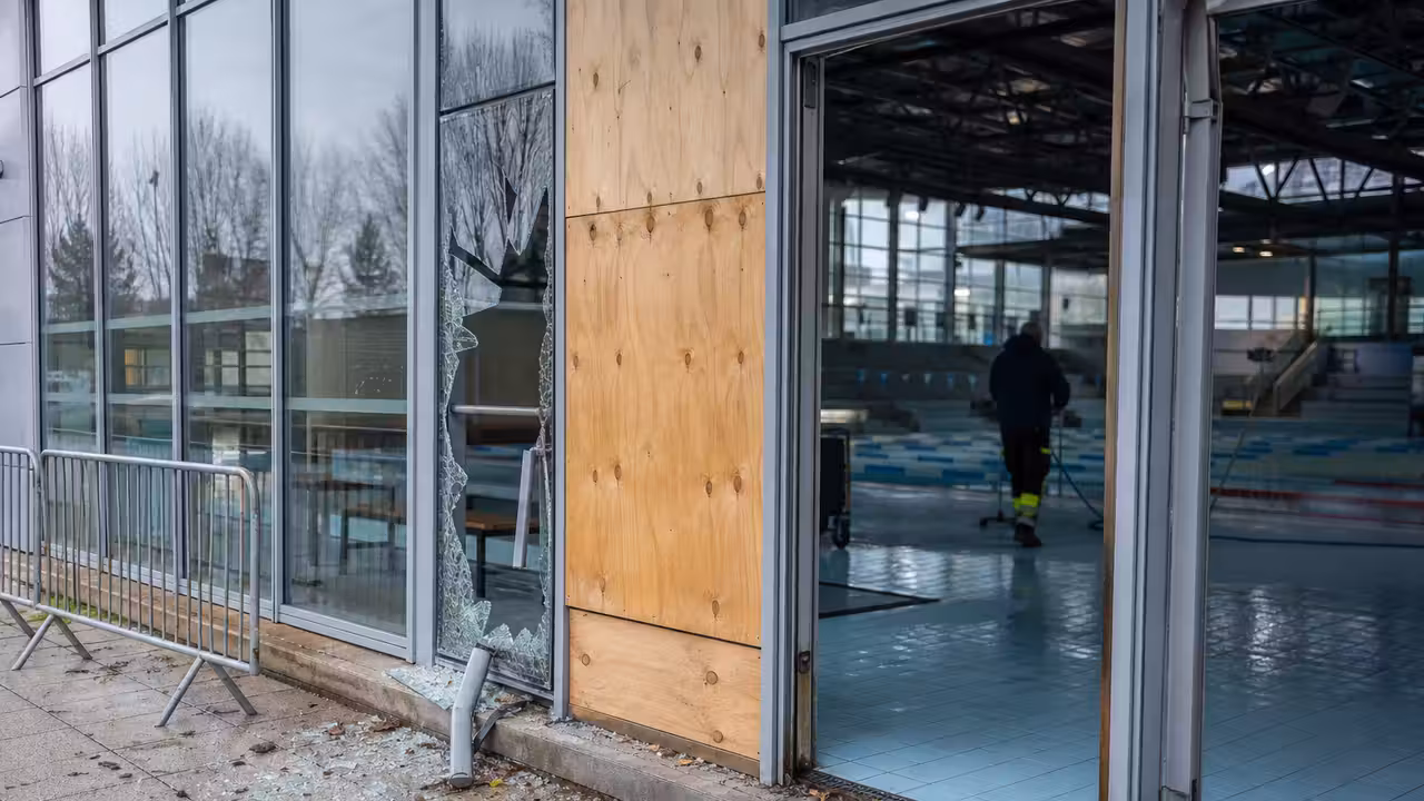 Façade vitrée d’un centre aquatique sécurisée après un choc, avec accès au bassin temporairement fermé