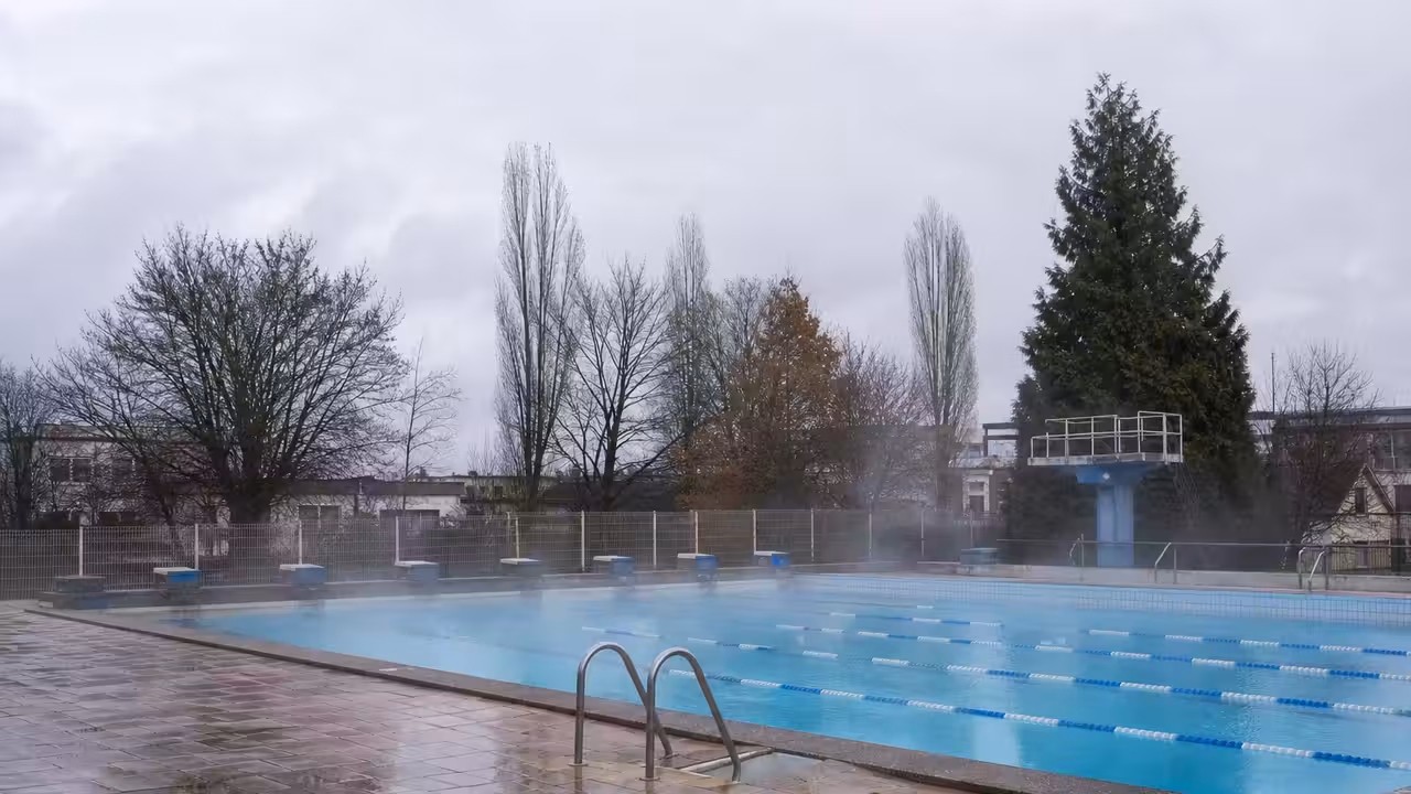 Bassin extérieur vide d’une piscine publique par temps froid, avec vapeur légère au-dessus de l’eau
