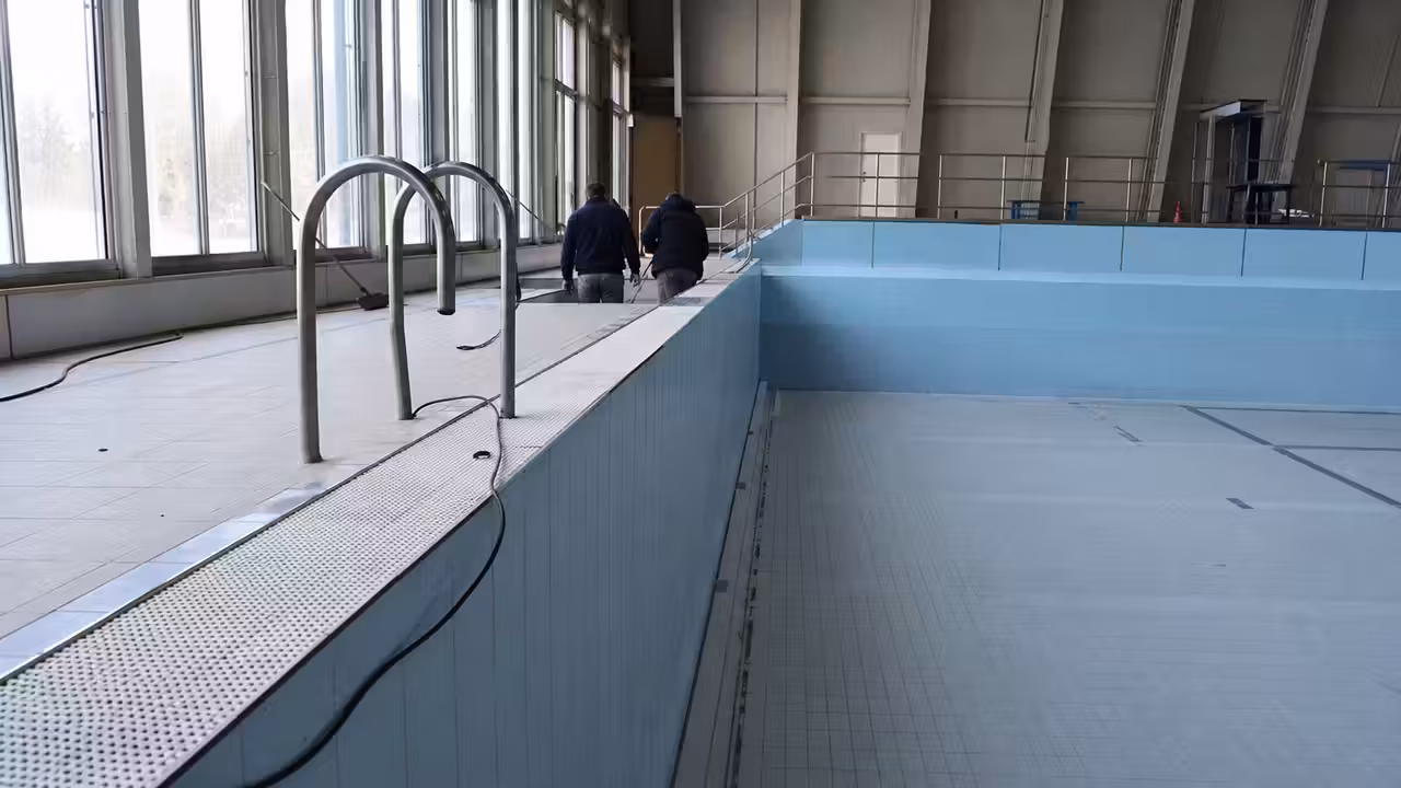 Grand bassin municipal vide, en cours d’inspection technique avant des travaux de réparation d’étanchéité