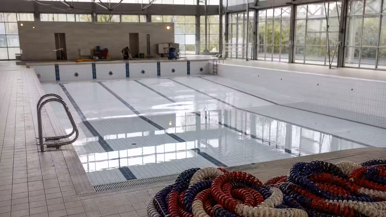 Bassin couvert vide pendant une maintenance technique, avec lignes d’eau retirées et lumière naturelle