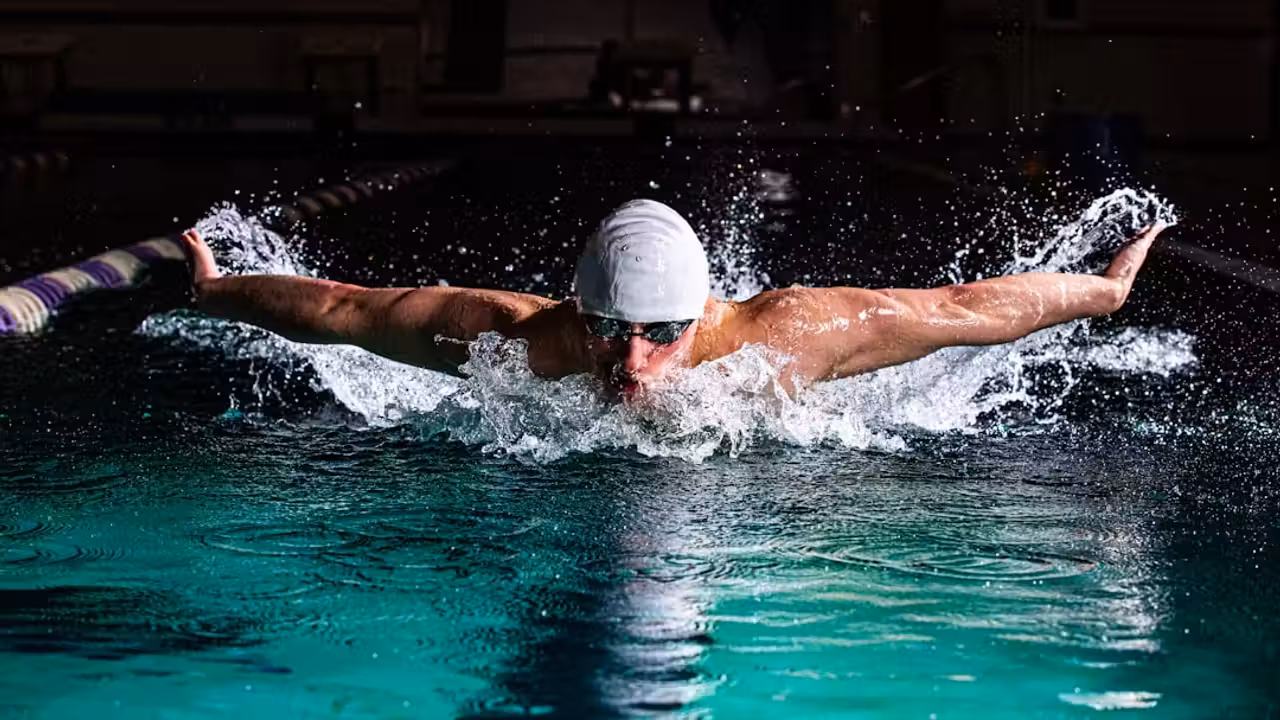 Projecteurs LED allumés dans les parois d’une piscine contemporaine au crépuscule