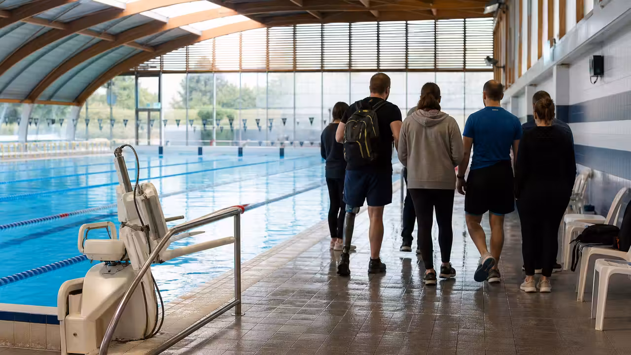 Bassin couvert municipal avec lignes d’eau, rampe d’accès et équipes préparant un accueil inclusif