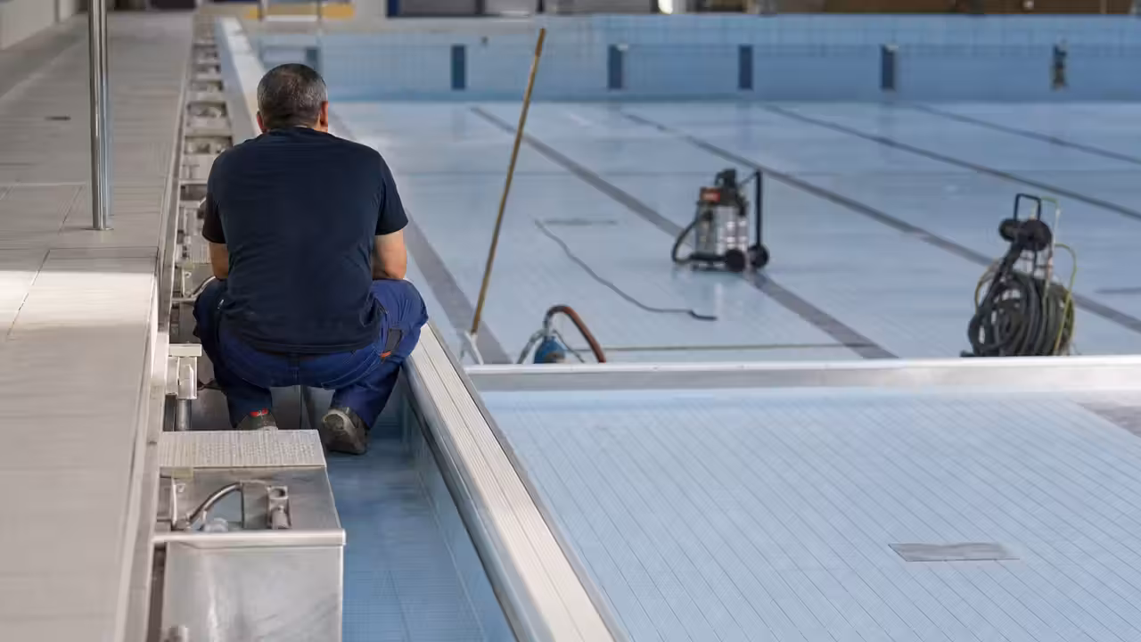 Bassin intérieur de piscine publique vide pendant une intervention de nettoyage et de maintenance technique