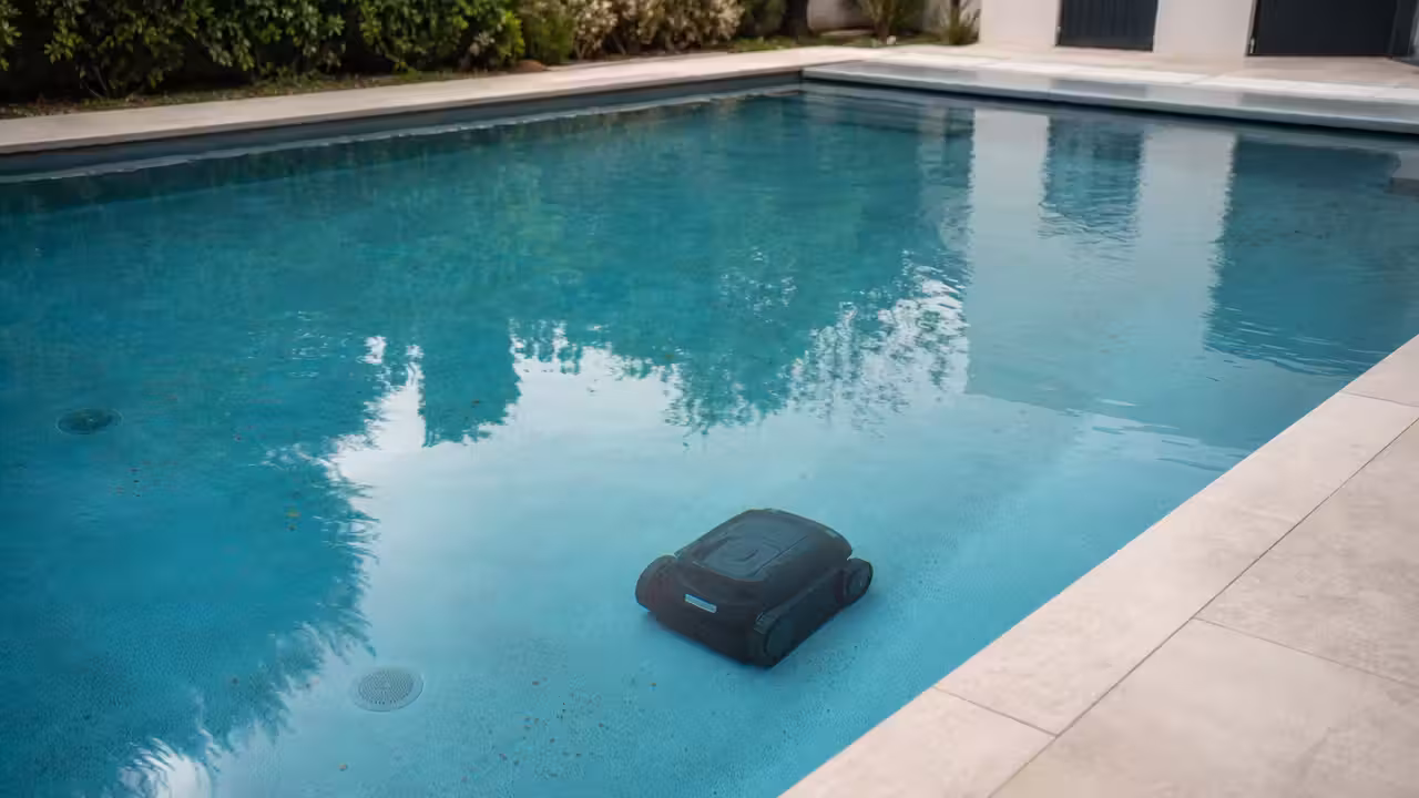 Robot de piscine sans fil nettoyant le fond d’un bassin rectangulaire aux parois claires