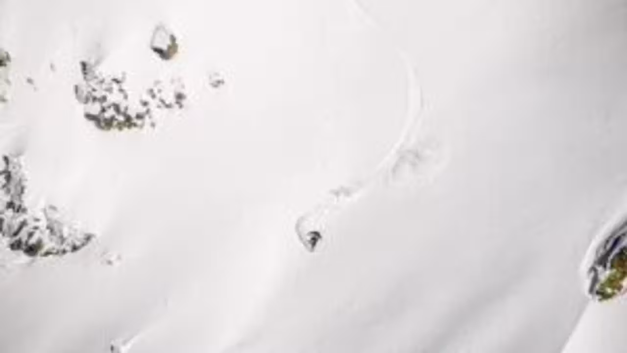 Skieur acrobatique casqué en plein saut au-dessus d’un bassin de réception lors d’un entraînement sur rampe