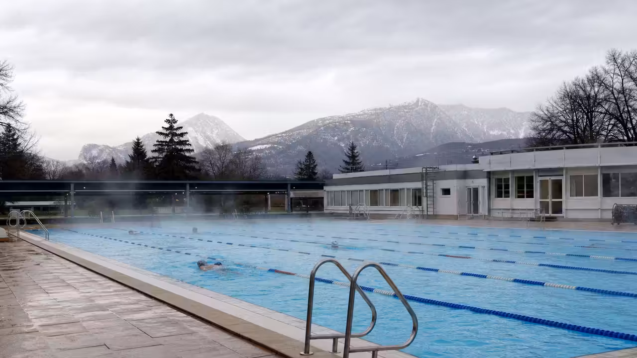 Bassin extérieur de 25 mètres chauffé, avec lignes d’eau et montagnes en arrière-plan à Grenoble