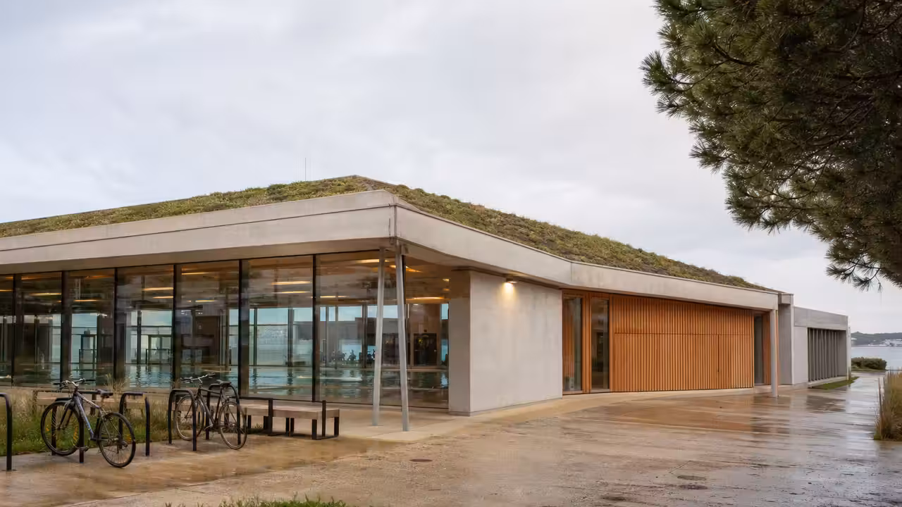 Vue extérieure de la piscine municipale Irandatz à Hendaye, avec toiture végétalisée et accès cyclable.