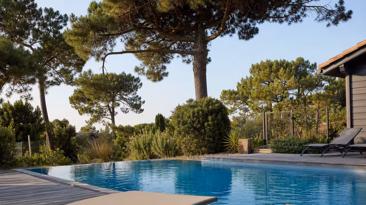 Piscine privée entourée de pins dans les Landes, avec terrasse calme loin de l’animation d’une plage