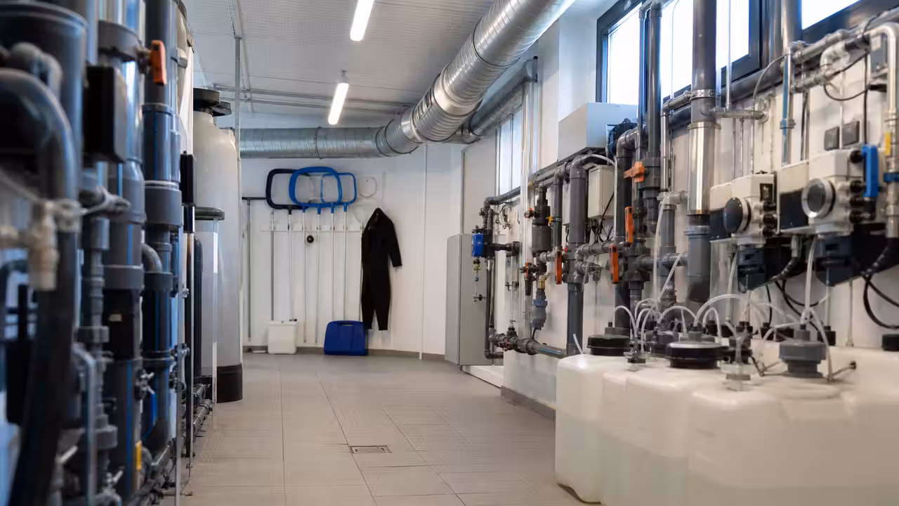 Entrée fermée d’un centre aquatique municipal avec bassin intérieur vide et panneaux de sécurité discrets