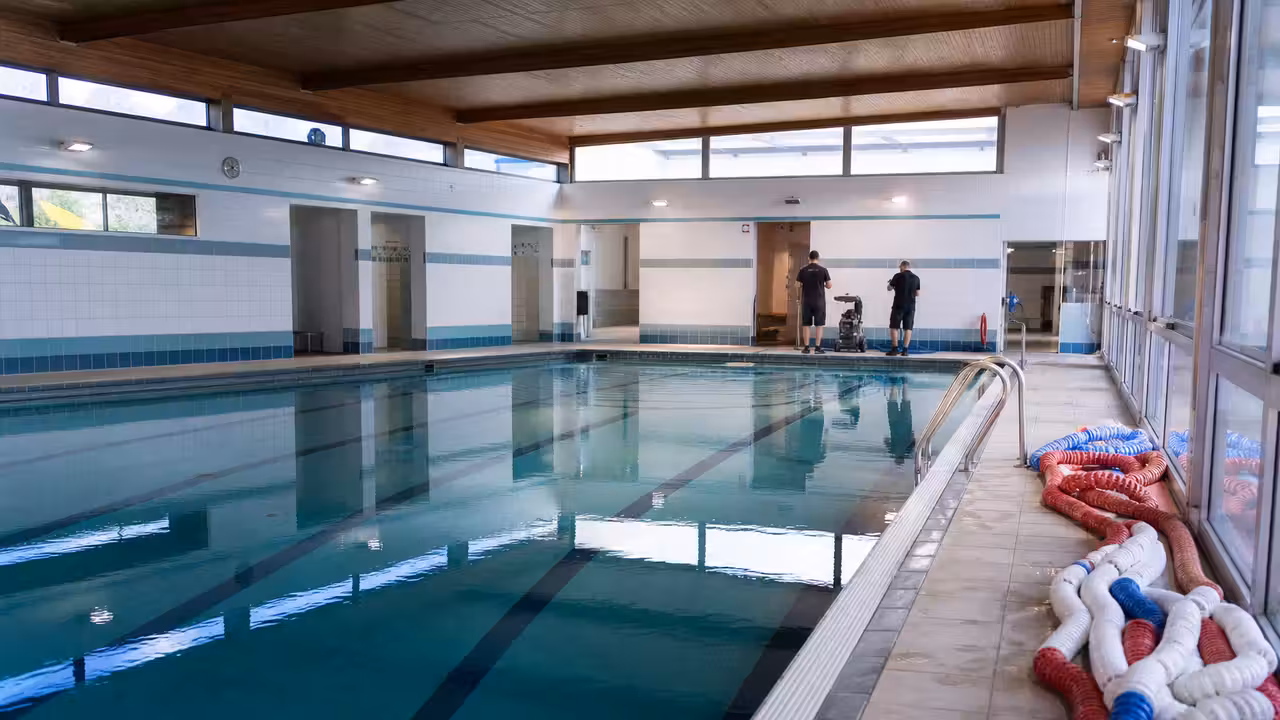 Bassin municipal vide et vestiaires lumineux, préparés pour une future réouverture au public