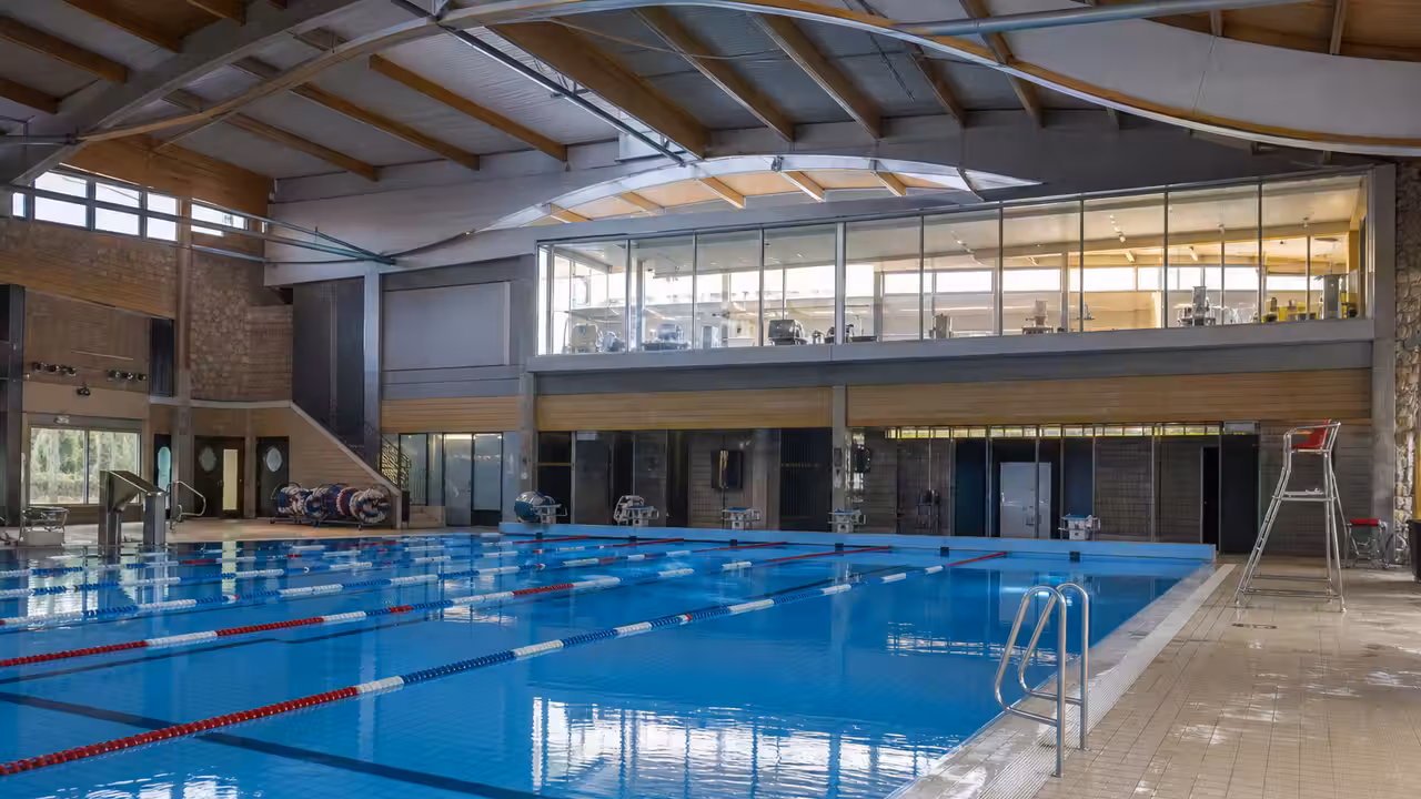 Couloirs d’un bassin municipal lumineux prêts à accueillir les nageurs après une réouverture